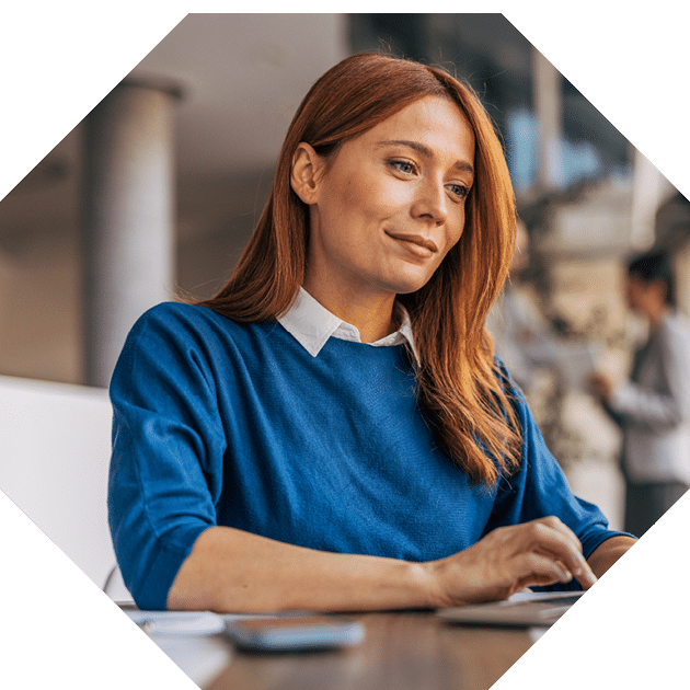 A successful businesswoman is using a laptop and working in the office
